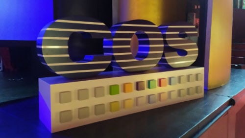 Letras corpóreas con gráfica impresa a rayas sobre un escenario iluminado