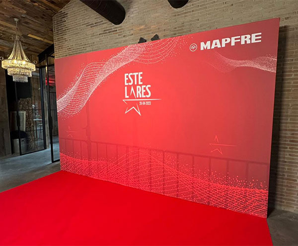 Fondo de evento con logotipo de MAPFRE y diseño en tonos rojos y blancos, ideal para presentaciones.